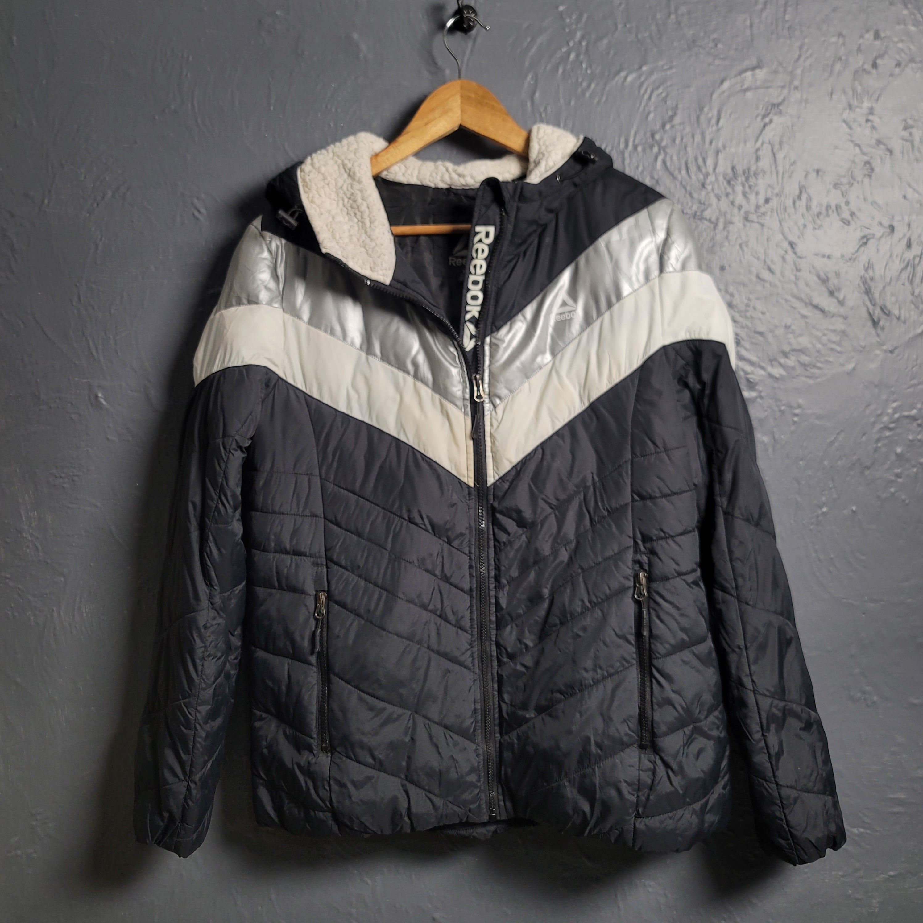 Reebok Black and white with Glacier Shield insulation. 2 zippered pockets and a Sherpa-like lined hood (Unisex)