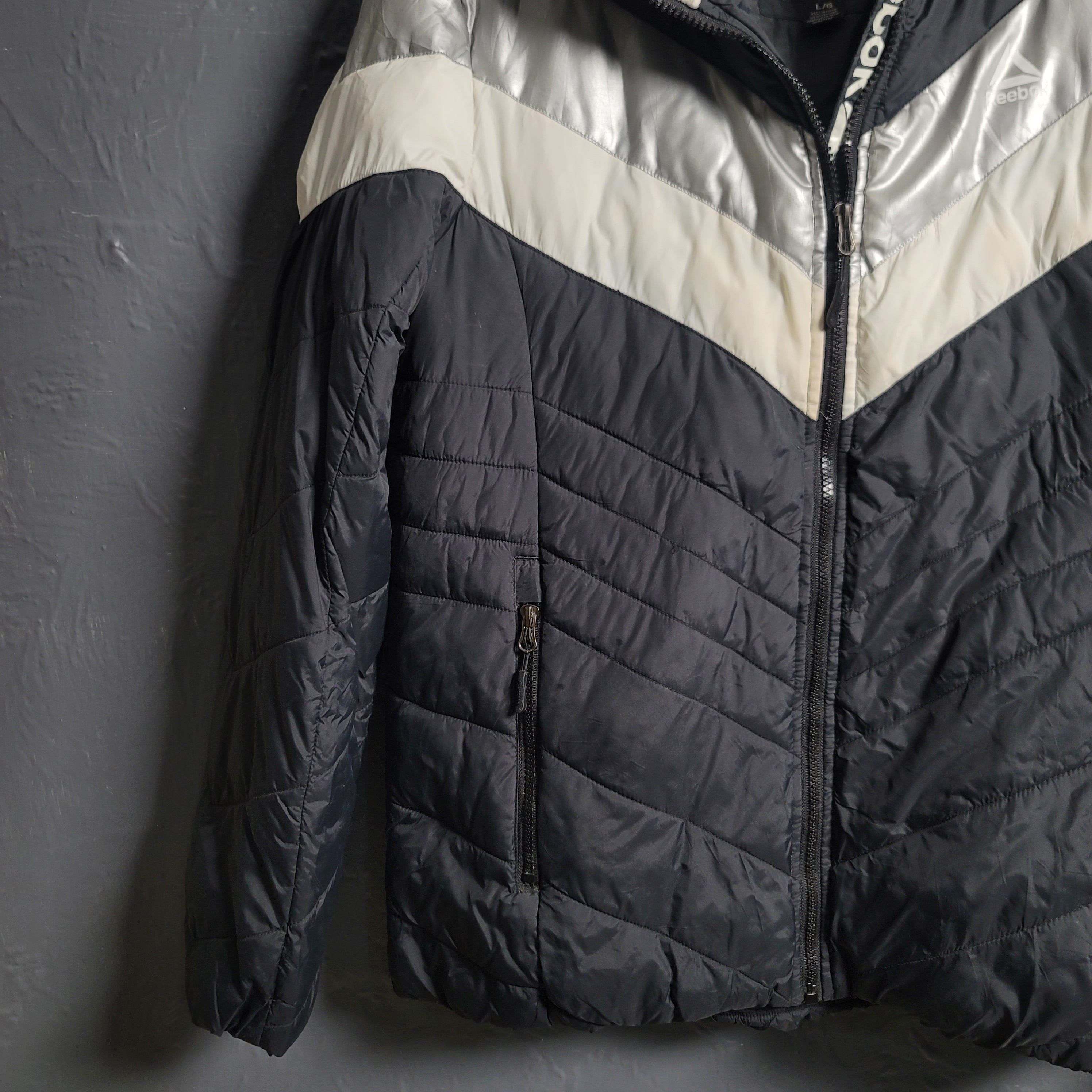 Reebok Black and white with Glacier Shield insulation. 2 zippered pockets and a Sherpa-like lined hood (Unisex)