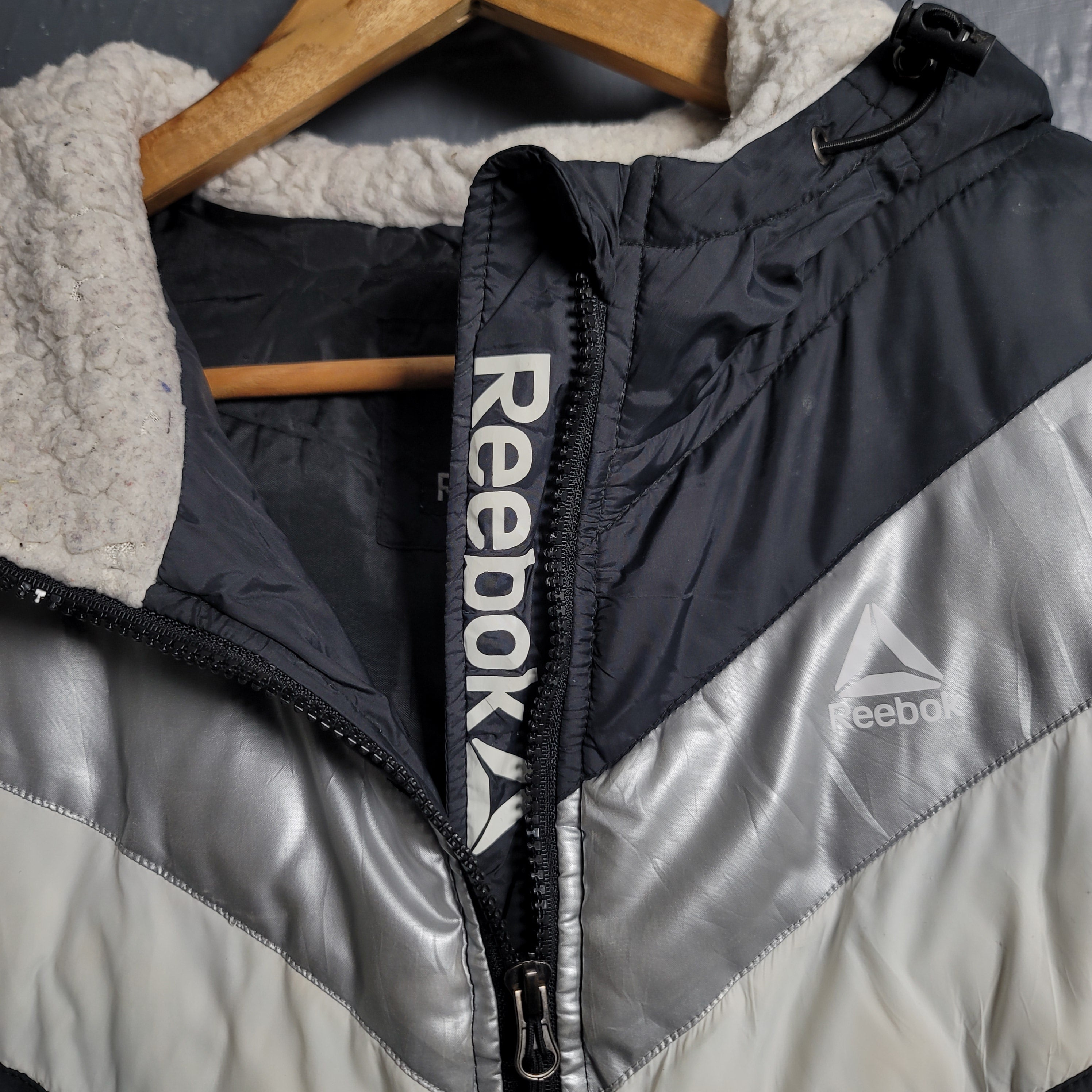 Reebok Black and white with Glacier Shield insulation. 2 zippered pockets and a Sherpa-like lined hood (Unisex)