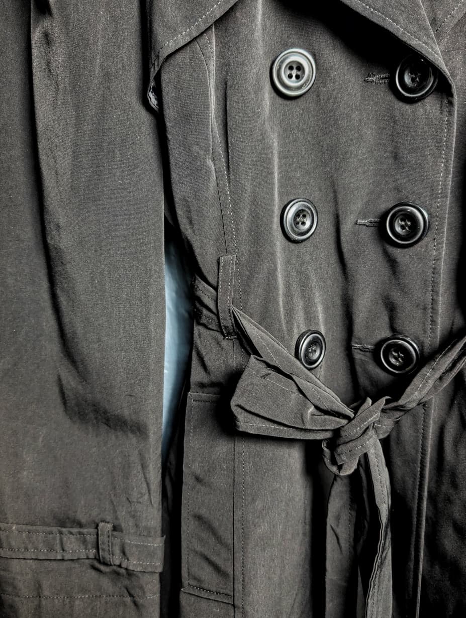 George jet black double-breasted trench coat with matching tie belt, and long tab-cuff sleeves