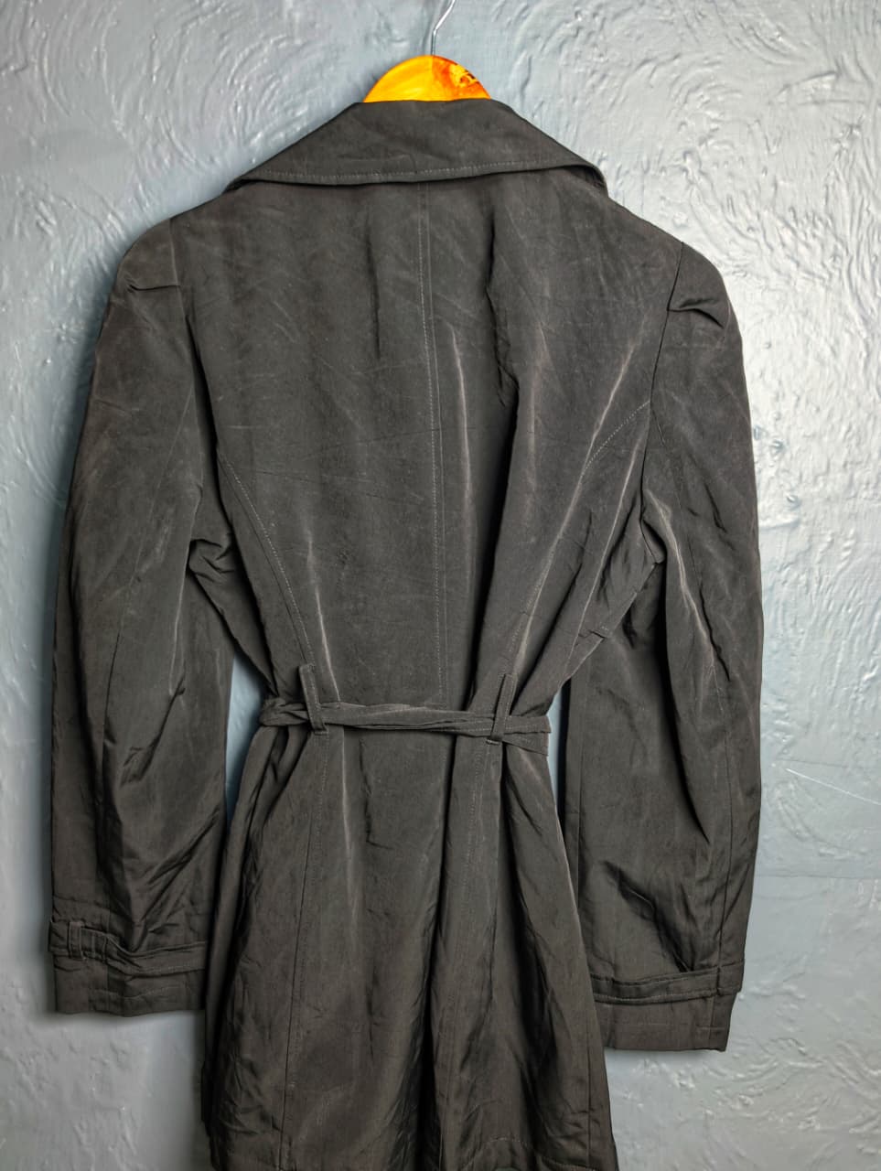 George jet black double-breasted trench coat with matching tie belt, and long tab-cuff sleeves