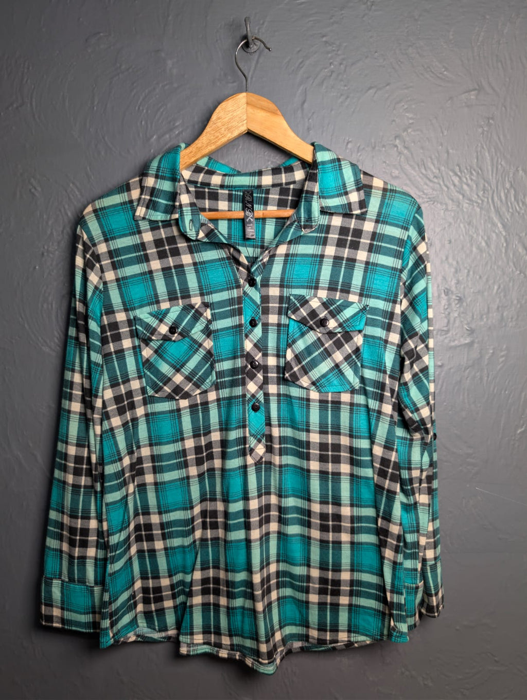 Women's turquoise and black plaid flannel shirt with chest pockets.