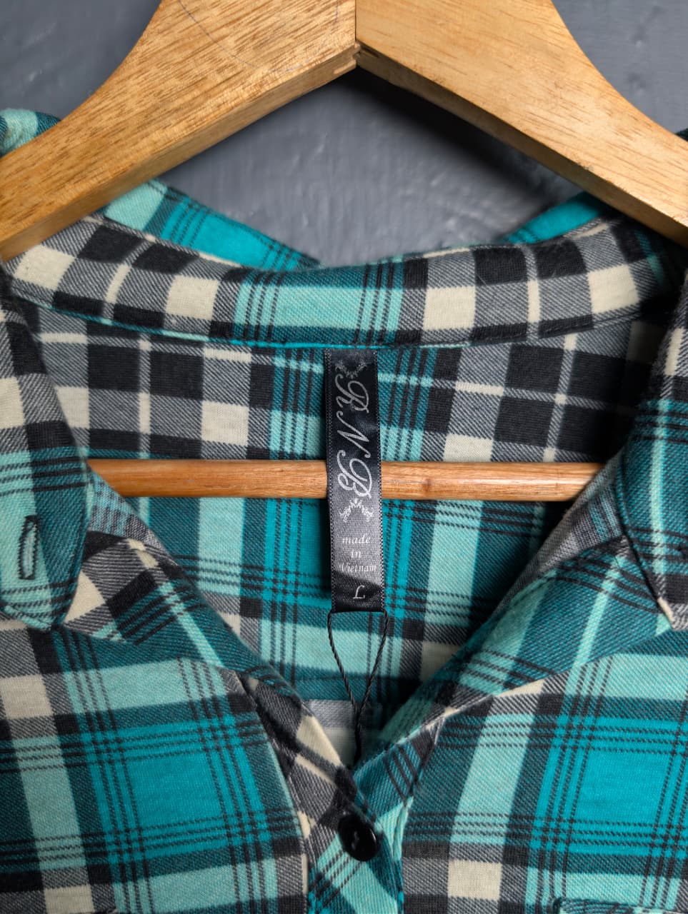 Women's turquoise and black plaid flannel shirt with chest pockets.