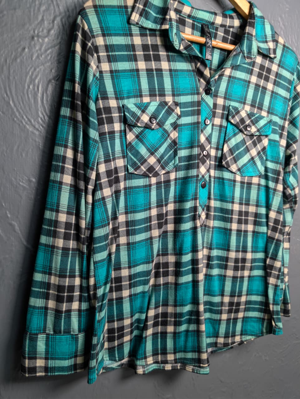 Women's turquoise and black plaid flannel shirt with chest pockets.