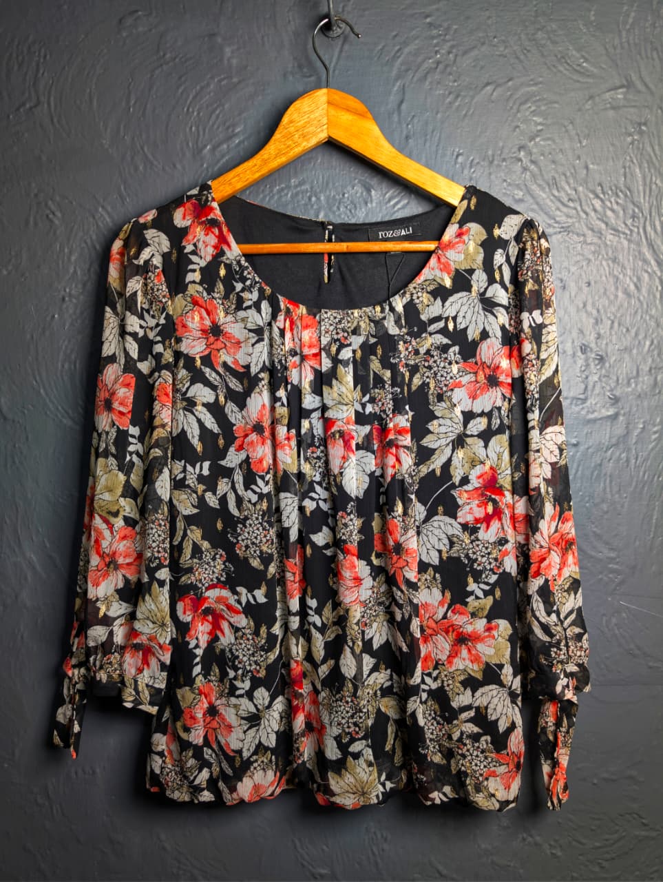 Floral blouse with 3/4 sleeves and a scoop neckline.