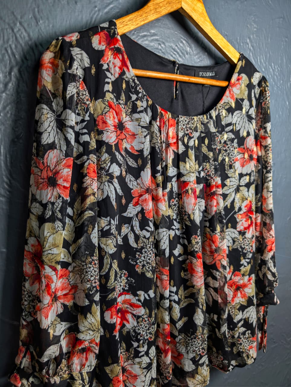 Floral blouse with 3/4 sleeves and a scoop neckline.