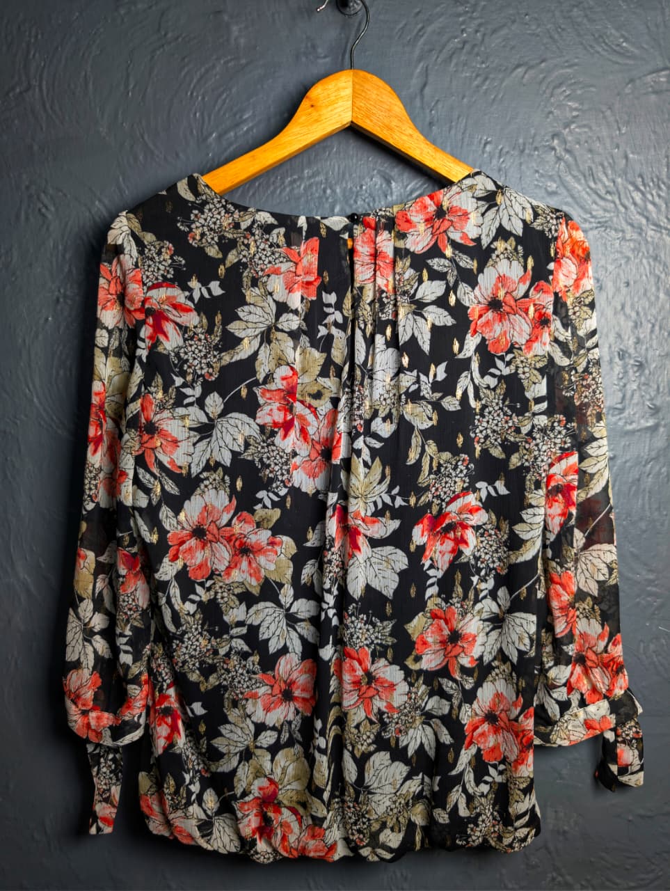 Floral blouse with 3/4 sleeves and a scoop neckline.