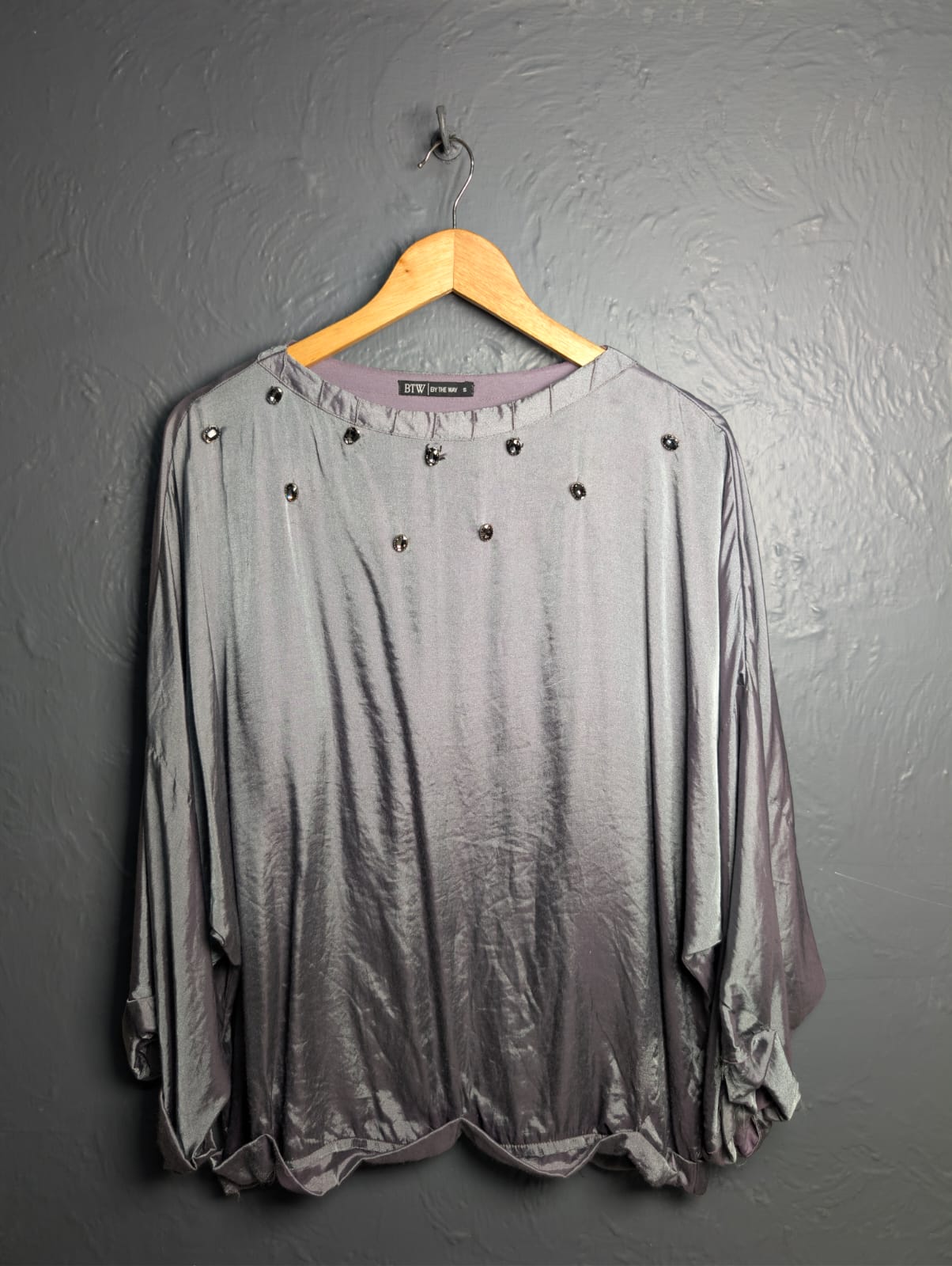 Silver satin-like top with rhinestone embellishments