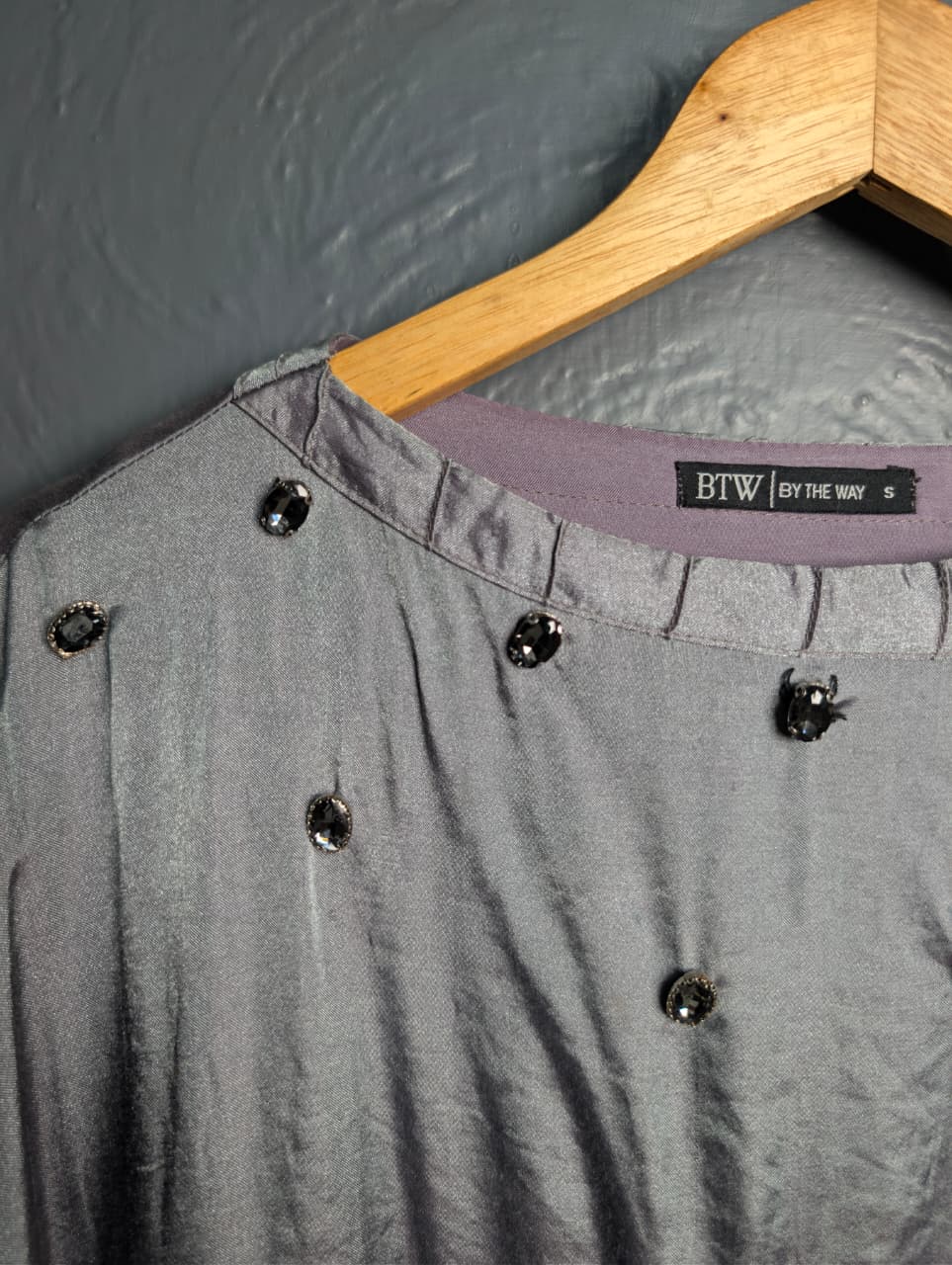 Silver satin-like top with rhinestone embellishments