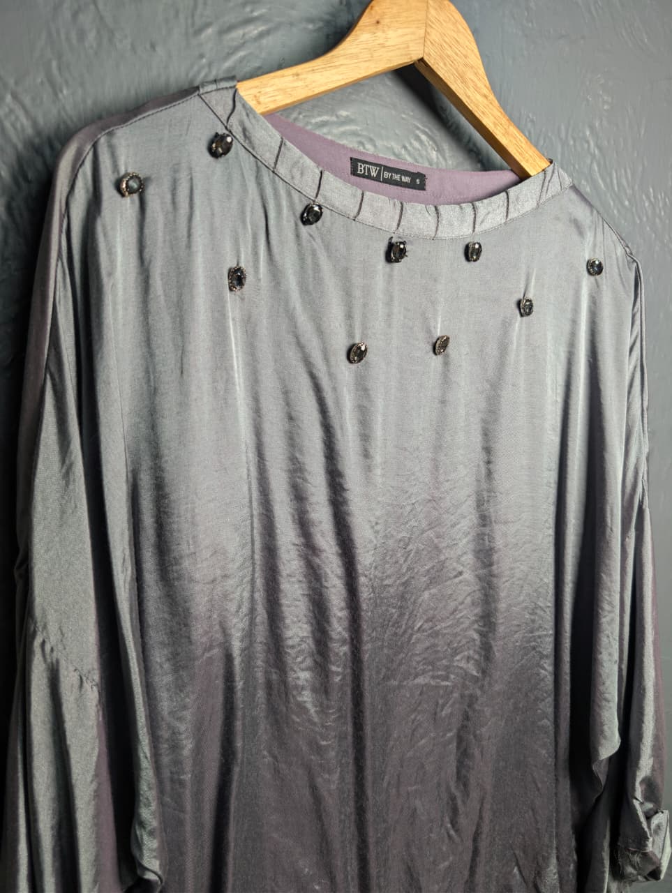 Silver satin-like top with rhinestone embellishments