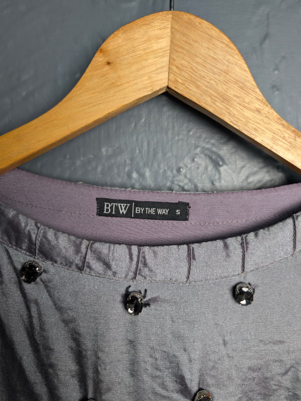 Silver satin-like top with rhinestone embellishments