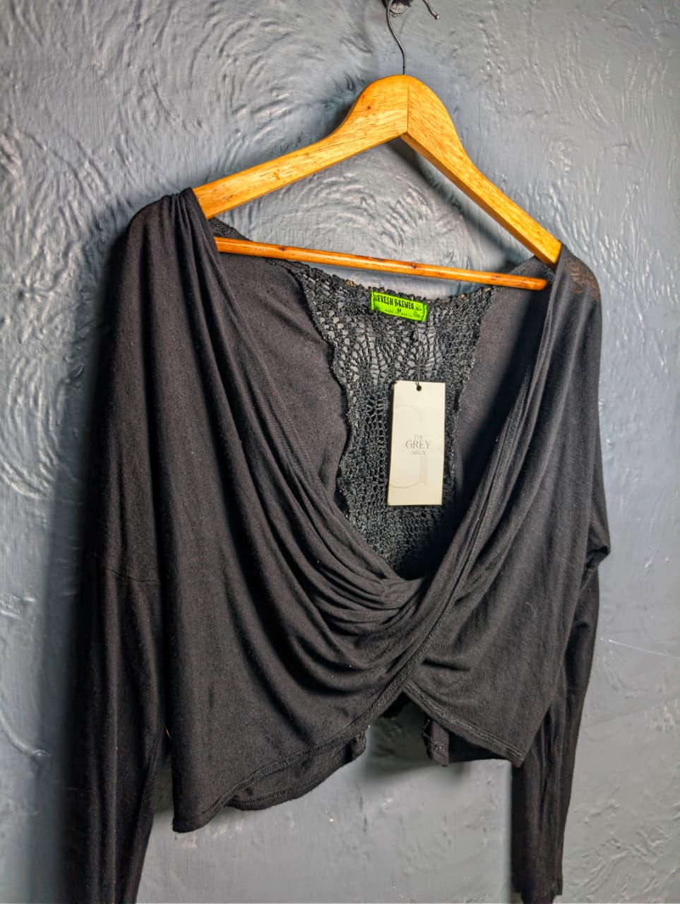 Black long-sleeve crop top with a twisted front design