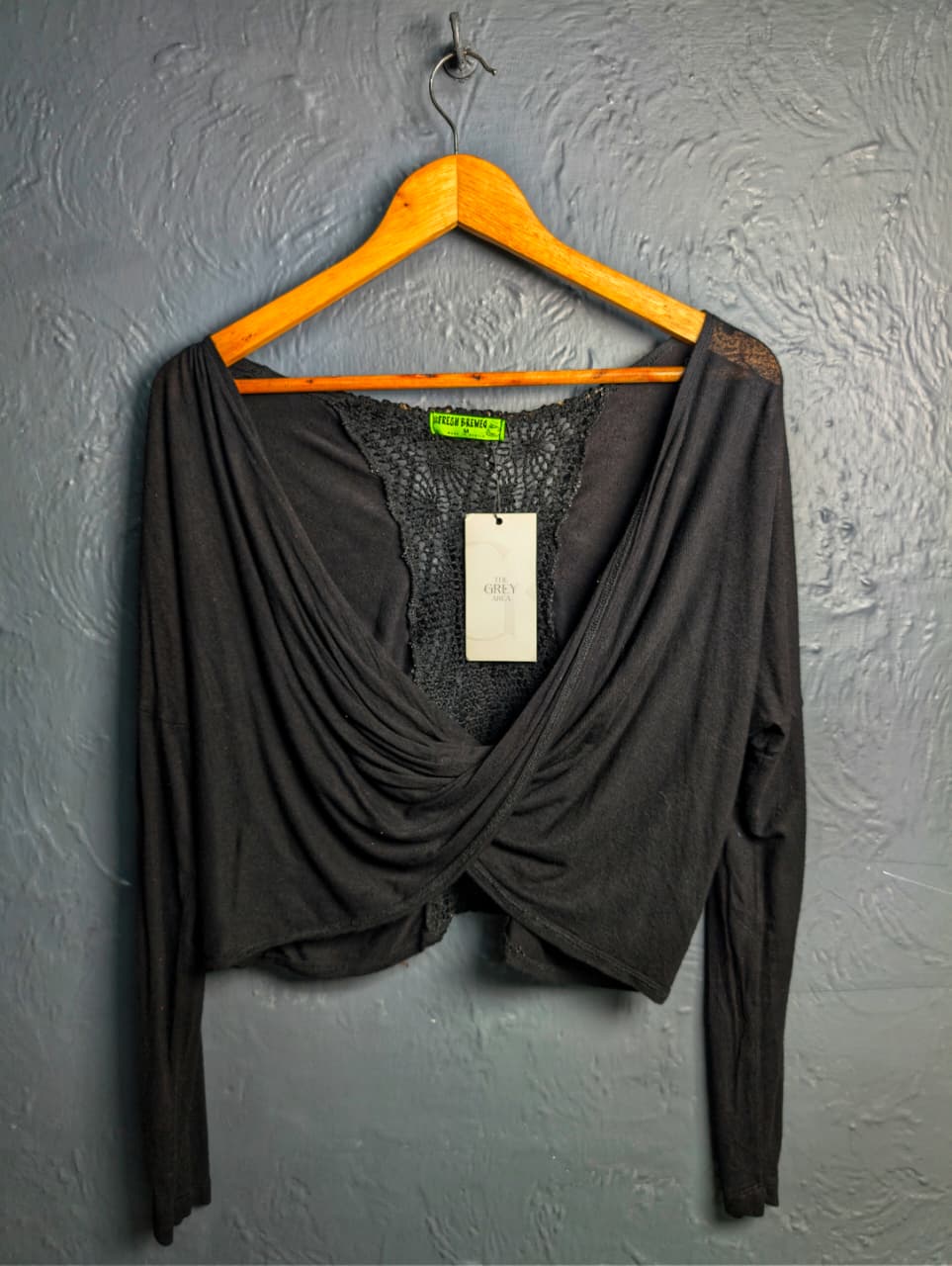 Black long-sleeve crop top with a twisted front design