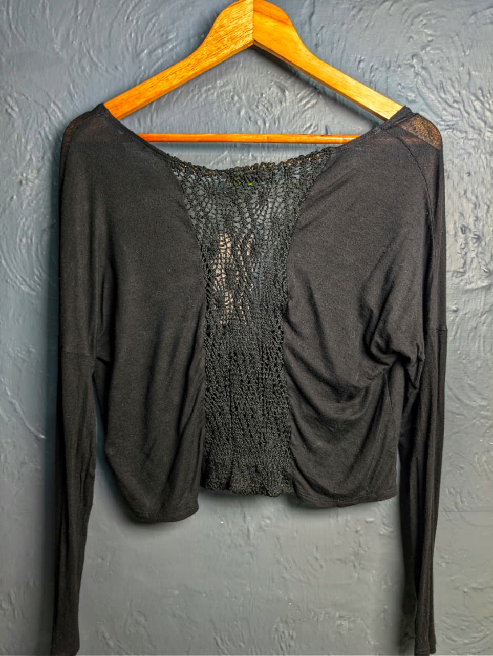 Black long-sleeve crop top with a twisted front design