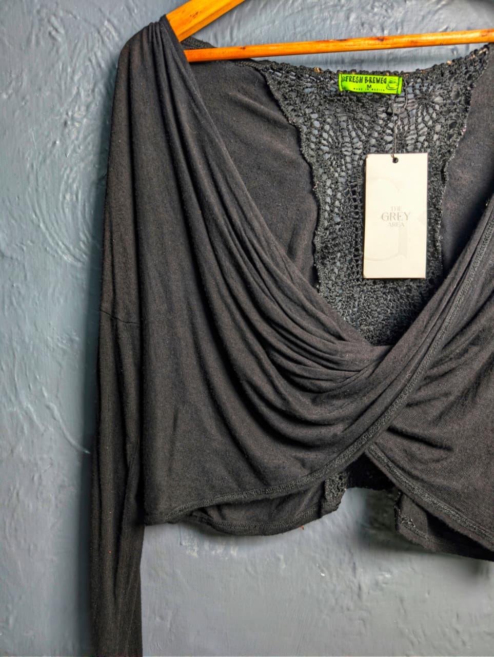 Black long-sleeve crop top with a twisted front design