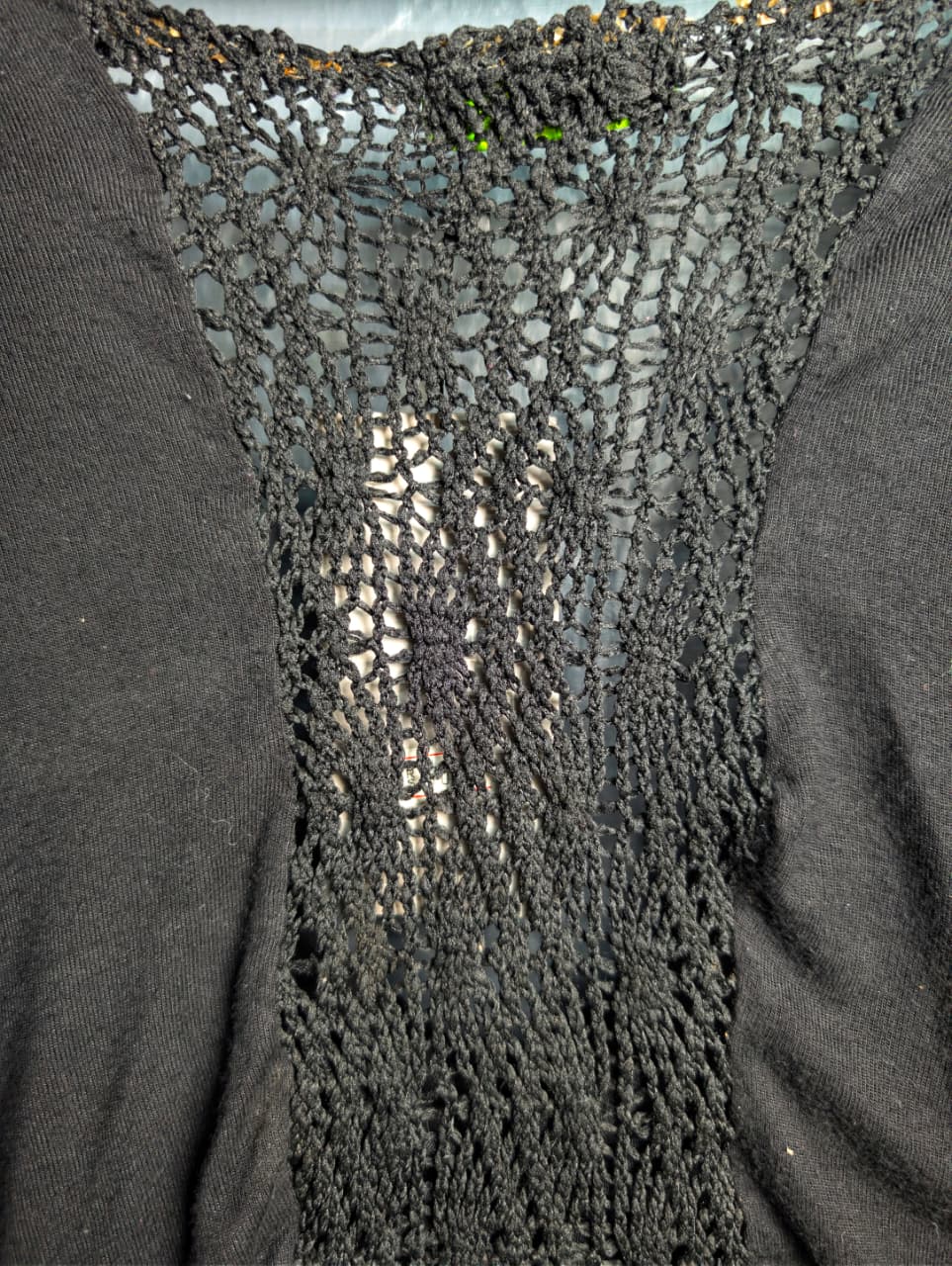 Black long-sleeve crop top with a twisted front design