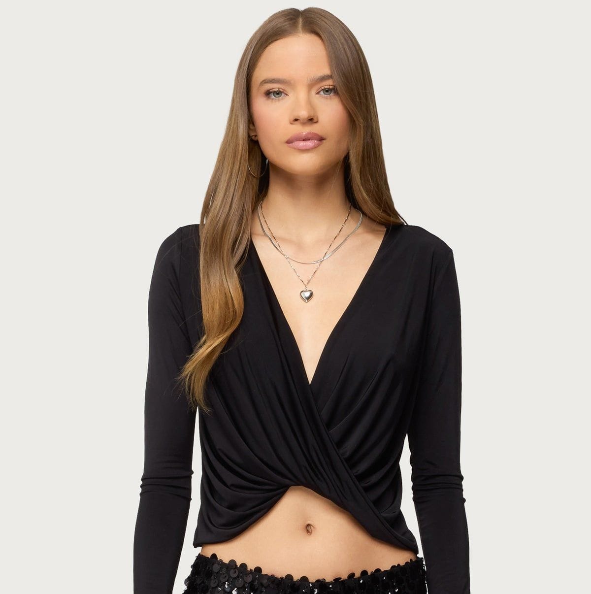 Black long-sleeve crop top with a twisted front design