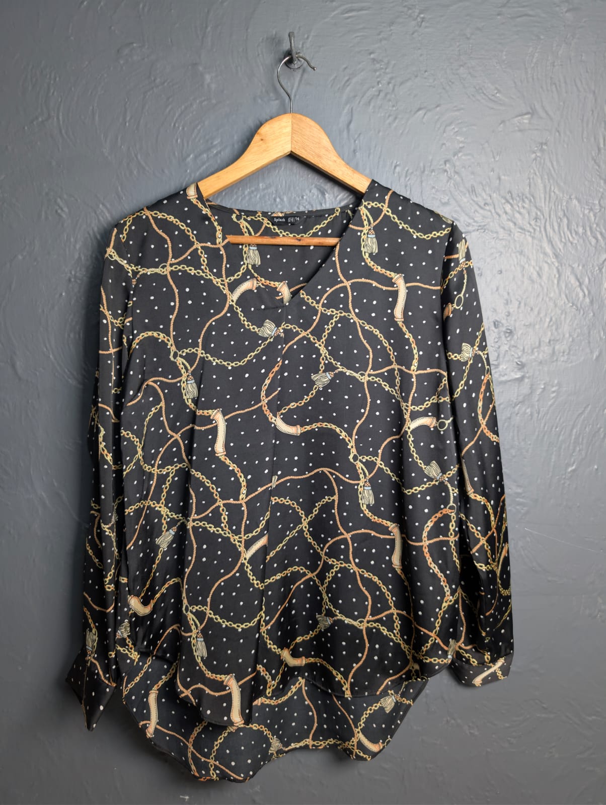 Black blouse with a gold chain and white polka dot print