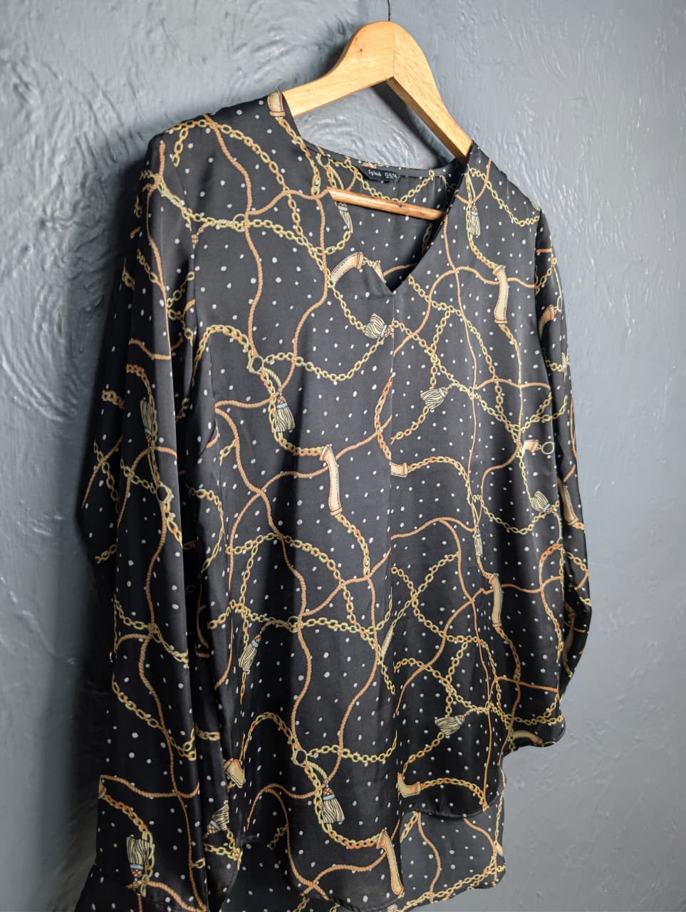 Black blouse with a gold chain and white polka dot print