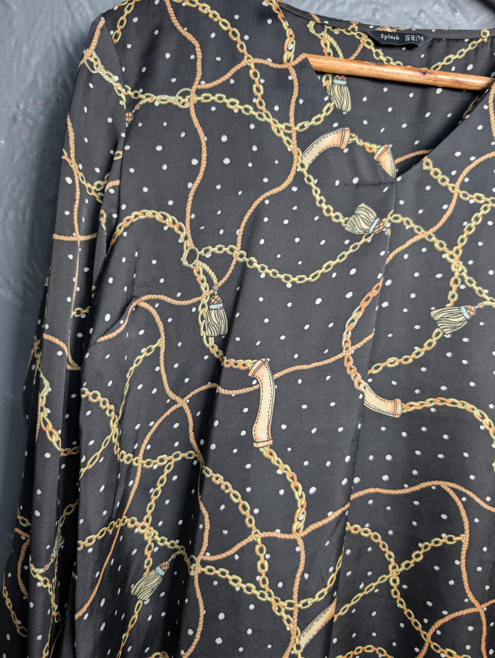 Black blouse with a gold chain and white polka dot print