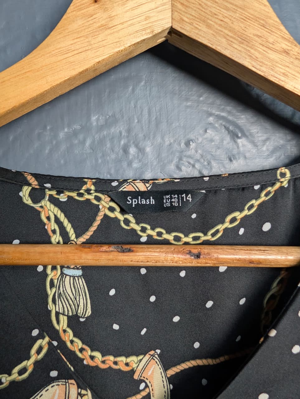 Black blouse with a gold chain and white polka dot print