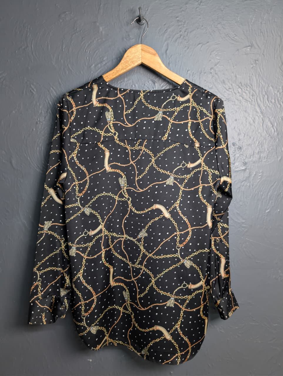 Black blouse with a gold chain and white polka dot print